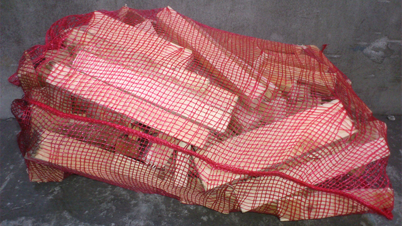 Red mesh bag containing firewood